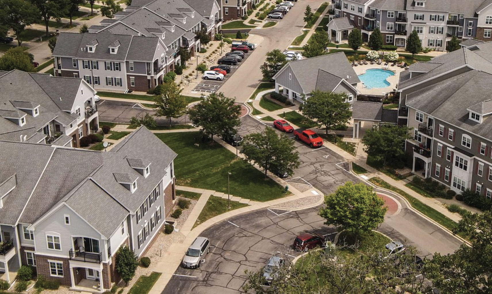 Aerial view of multifamily residential community featuring modern architecture, landscaped grounds, and a swimming pool, relevant to Wangard Partners' multifamily investment projects.