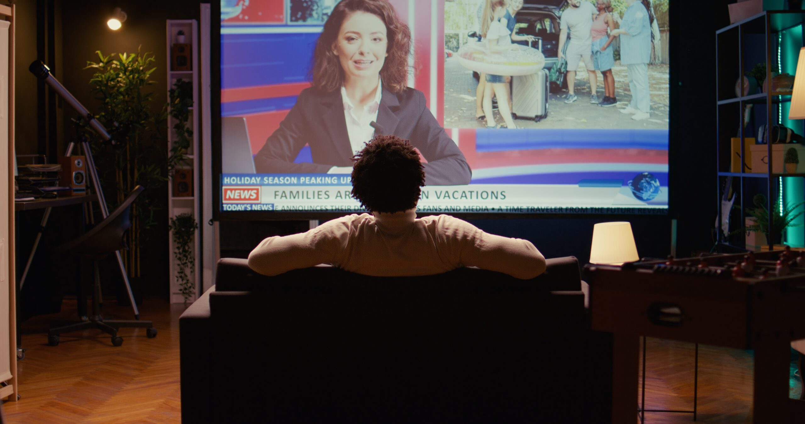 Man sitting on chair facing television watching election night coverage