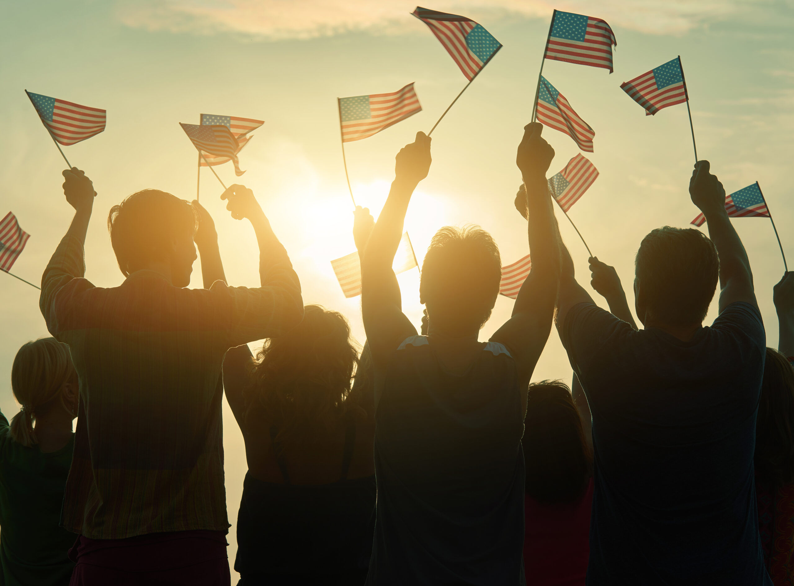 Silhouettes of group waving small American Flags
